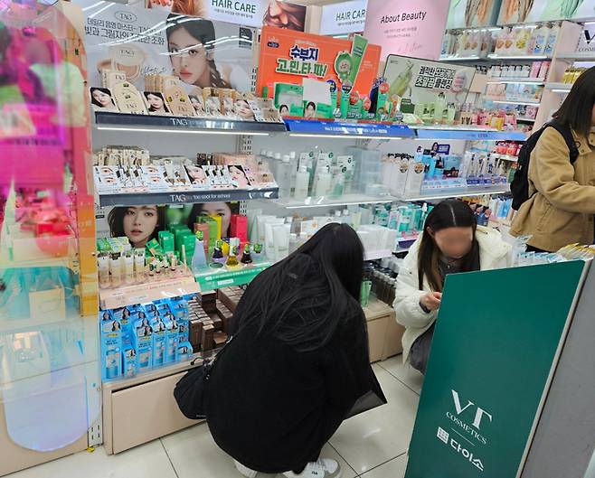 서울 중구의 한 다이소 매장에서 뷰티 제품을 살펴보고 있는 소비자들.