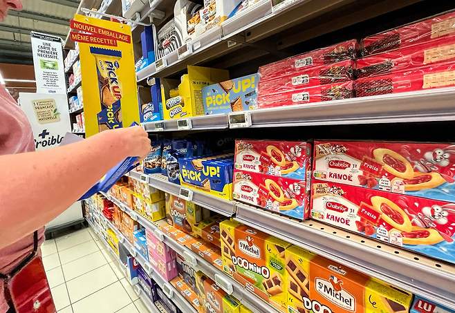 프랑스의 한 슈퍼마켓에서 소비자가 과자에 표시된 정보를 보고 있다. 사진 출처: AFP
