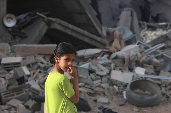 25일(현지시간) 가자지구 남부 라파에서 한 소녀가 밤새 이어진 이스라엘군의 폭격으로 무너진 건물 잔해를 바라보고 있다. AFP연합뉴스