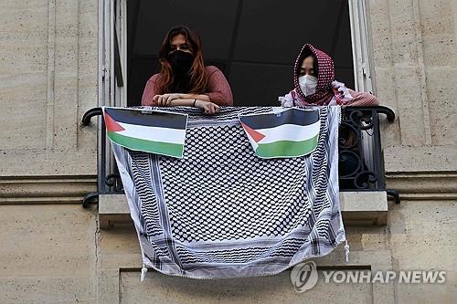 (파리 AFP=연합뉴스) 26일(현지시간) 프랑스 파리의 정치대학(시앙스포)에서 친팔레스타인 시위대가 건물 점거 농성 중 창밖을 바라보고 있다.