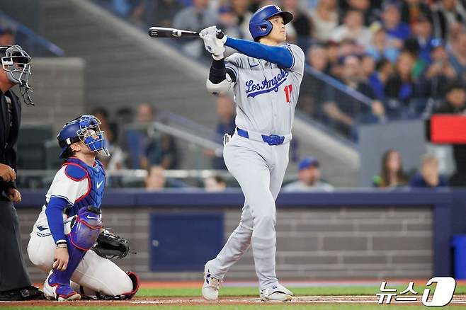 LA 다저스 오타니 쇼헤이가 27일(한국시간) 캐나도 온타리오주 토론토 로저스 센터에서 열린 메이저리그(MLB) 토론토 블루제이스와 경기에서 홈런을 치고 있다. ⓒ AFP=뉴스1