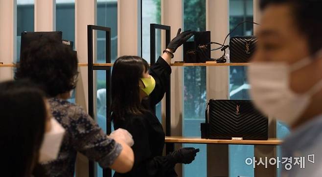 롯데쇼핑이 면세점 명품 대전 오프라인 판매를 시작한 25일 서울 노원구 롯데백화점 행사장에서 방문객들이 제품을 고르고 있다./김현민 기자 kimhyun81@