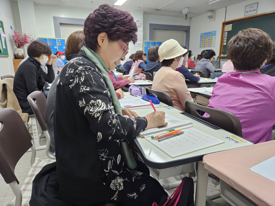 윤연례(72)씨가 진형중고등학교 고2 영어 시간에 선생님 강의를 열심히 받아 적고 있다.