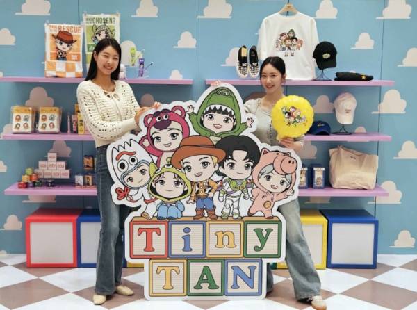 모델들이 2일 서울 서초구 반포동 신세계백화점 강남점에 마련된 ‘토이 스토리-타이니탄’ 팝업스토어에서 여러 캐릭터가 그려진 입간판을 사이에 두고 기념사진을 찍고 있다. 신세계백화점 제공