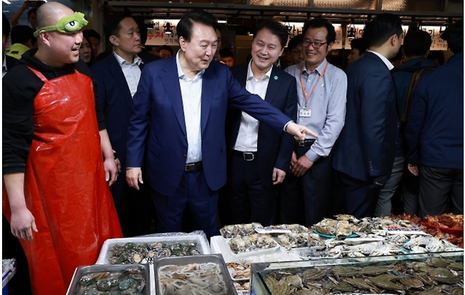 윤석열 대통령이 10일 오후 서울 서대문구 영천시장을 찾아 수산 매장에서 상인과 대화하며 수산물을 살피고 있다. 연합뉴스
