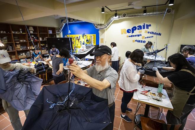 5월23일 수리상점 곰손에서 열린 우산 수리 양성 과정에서 수강생들이 고장난 우산을 줄에 매달아 고치고 있다. ⓒ시사IN 신선영
