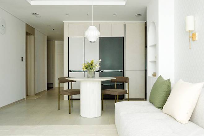 요리를 전혀 하지 않아 활용도가 떨어지는 아일랜드 식탁을 철거하고 그 자리에 거실의 포인트가 될 수 있는 아치형 선반과 원형식탁을 배치했다.