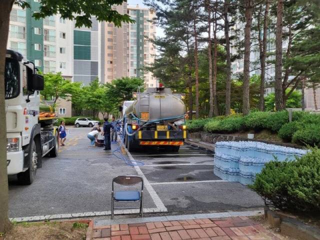 ▲ 춘천의 한 아파트에서 단수가 발생, 한 주민이 관리동 앞에 제공된 식수를 통에 담고 있다.