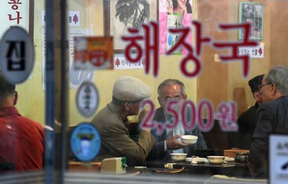 서울 종로구 한 해장국집에서 어르신들이 막걸리를 마시며 얘기를 나누고 있다. 서울신문DB.