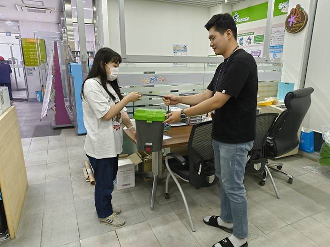 신수동 주민센터에서 구민이 음식물류 폐기물 문전수거통을 배부받고 있다. 마포구청 제공