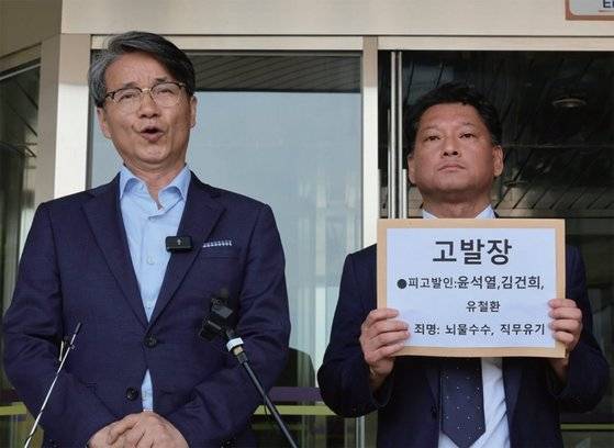 6월 17일 정부과천청사 고위공직자범죄수사처 민원실 앞에서 최재영 목사와 시민단체 사법정의 바로세우기시민행동 (사세행)이 뇌물수수와 김영란법 위반, 직무유기 혐의 등으로 윤석열 대통령 부부 및 유철환 국민권익위원장을 고발하고 있다. 김건희 여사의 명품 가방 수수 등 정권에 치명적인 사건에서 대통령실의 잘못이 드러날 경우 탄핵은 급물살을 탈 수도 있다. / 사진:연합뉴스