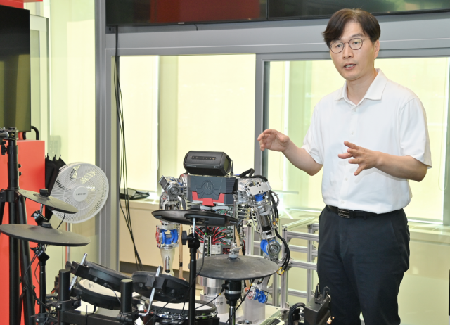 김익재 한국과학기술연구원(KIST) AI·로봇연구소장이 드럼 치는 로봇 옆에서 그 원리를 설명하고 있다.