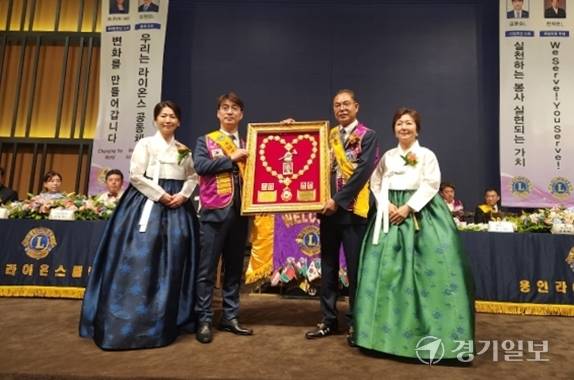 24일 용인라이온스클럽 제54대 김문순 이임회장 내외분(왼쪽)이 제55대 한재현 취임회장 내외분에게 추대패를 전달하고 있다. 김정오기자