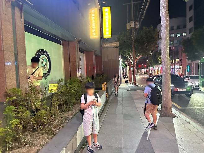 27일 밤 서울 강남구 대치동 한 수학학원 수업을 마치고 귀가하기 위해 보호자를 기다리고 있는 학생들의 모습. 이혜인 기자