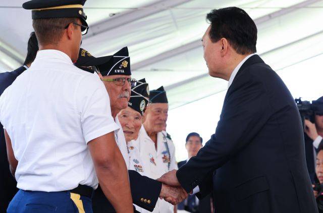 윤석열 대통령이 8일(현지시간) 미국 하와이 태평양국립묘지(펀치볼)를 방문해 헌화한 뒤 6·25전쟁 참전용사들과 인사를 나누고 있다. 연합뉴스