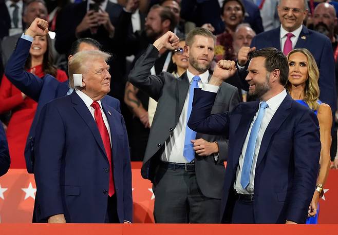 도널드 트럼프 전 대통령이 15일(현지시각) 위스콘신주 밀워키에서 열린 공화당 전당대회에서 오른쪽 귀에 흰 사각 붕대를 붙인 채 부통령 후보 JD 밴스 연방 상원의원과 함께 모습을 드러내고 있다. /AP 연합뉴스