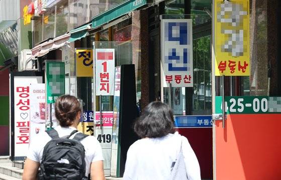 지난 10일 서울 시내의 부동산 사무실 앞으로 시민들이 지나가고 있다. 뉴시스