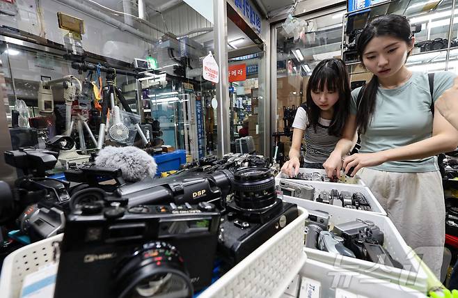 22일 서울 종로구 세운상가 내 중고카메라 매장에서 손님들이 구형 디지털카메라를 살펴보고 있다. 2024.7.22/뉴스1 ⓒ News1 김도우 기자