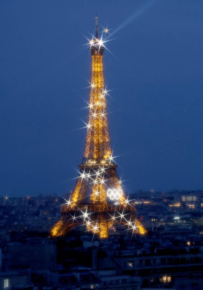에펠탑이 25일(한국시간) 2024파리올림픽 개막을 앞두고 오륜기와 함께 반짝이고 있다. 100년 만에 파리에서 열리는 대회이자 코로나19 팬데믹 이후 첫 올림픽이라 전 세계인의 관심이 뜨겁다. 파리|뉴시스