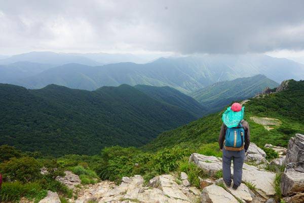 가지산 정상에 선 취재팀 앞으로 재약산과 천황산은 시커면 구름을 뒤집어썼고, 발아래 길게 뻗은 골짜기는 용수골이다.
