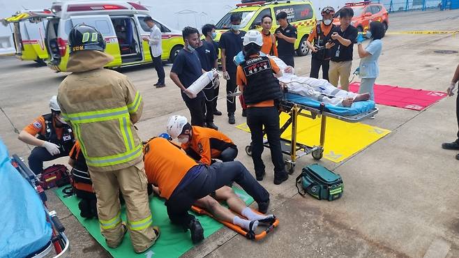 오늘(14일) 오전 제주항에 입항한 크루즈선에서 화재가 발생한 가운데 연기를 마신 선원 3명이 치료를 받는 모습. (사진, 제주소방안전본부)