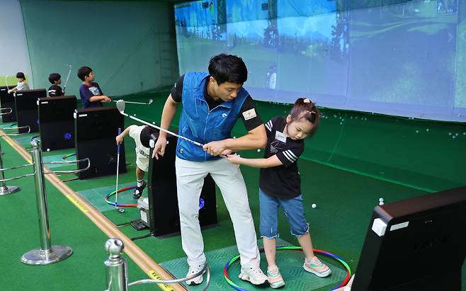 Elementary school students who participated in "2024 Neulbom Summer School" learn to play screen golf. (Yonhap)