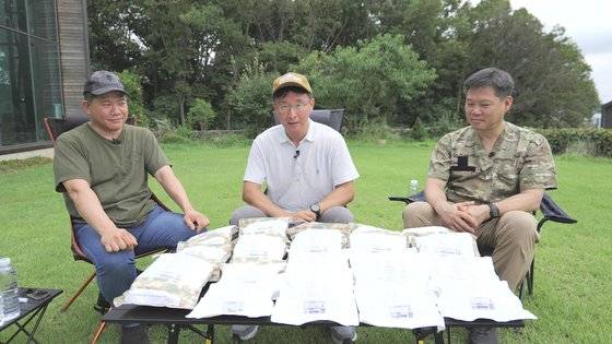 전투식량 L형을 기자(가운데)와 함께 시식할 김민수 대표(왼쪽)와 태상호 기자. 전투식량 느낌을 살리려 야외에서 촬영했다. 덕분에 무더위가 심해 다들 땀을 많이 흘렸다. 기자는 얼굴이 익었다. 동영상 캡처