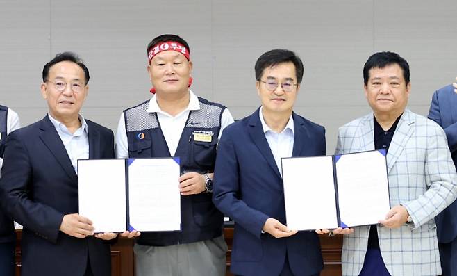 4일 경기 수원시 경기지방노동위원회에서 경기도 버스 노사 관계자들이 합의문에 서명한 뒤 기념촬영을 하고 있다. 왼쪽부터 김태기 중앙노동위원회 위원장, 이기천 경기도버스노동조합협의회 의장, 김동연 경기도지사, 김기성 경기도버스운송사업조합 이사장. 사진제공=경기도