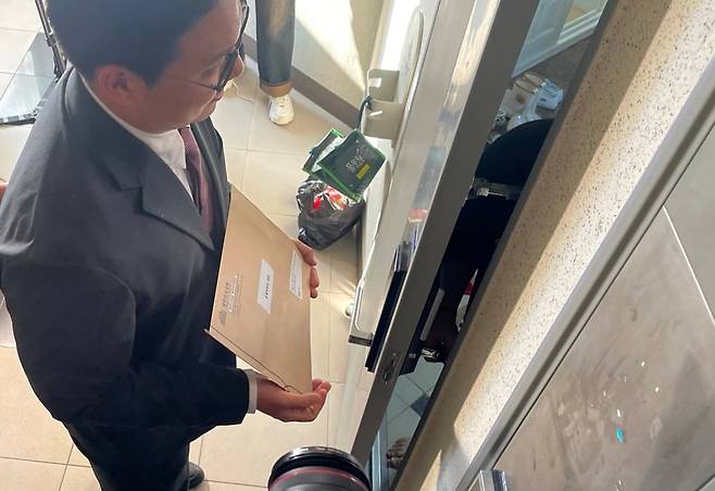 국회 입법사무관이 10일 명태균씨에 대한 동행명령장을 집행하기 위해 경남 창원 명씨 자택을 방문했으나, 명씨를 만나지 못하고 그 가족과 대화하고 있다. /뉴스1