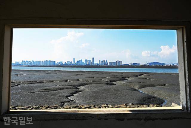 배곧한울공원 초소 창으로 보는 풍경. 넓은 창 너머 인천 송도국제도시가 신기루처럼 솟아 있다. 배곧한울공원 초소 창으로 보는 풍경. 넓은 창 너머 인천 송도국제도시가 신기루처럼 솟아 있다.
