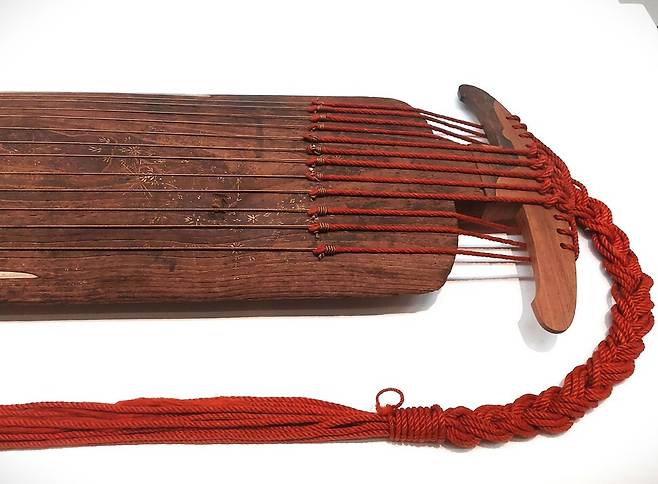 풀꽃을 아리땁고 정겨운 금박 무늬로 표현한 신라금의 앞부분 몸체. 위쪽 양이두와 몸체를 잇는 현줄과 연결한 노끈의 모습도 1000년 전 것이라고는 믿기 어려울 정도로 보존 상태가 좋다. 노형석 기자