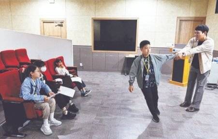이 팀장(맨 오른쪽)과 전상윤 학생기자가 어떻게 소행성이 지구 궤도를 돌고 나가는지를 몸으로 표현했다.