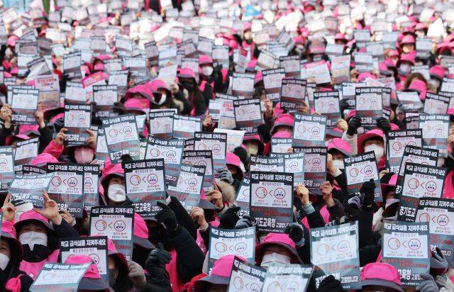 지난해 2월 경기도 수원시 경기도교육청 앞에서 전국학교비정규직노조 경기지부 조합원들이 급식실 노동환경 개선 및 산업재해 추방 등을 요구하며 구호를 외치고 있다.연합뉴스