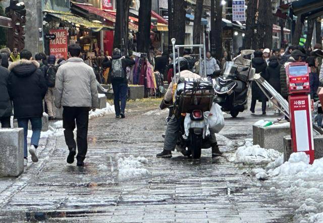 28일 서울 종로구의 한 도로에서 배달 기사가 폭설로 미끄러워진 도로를 조심조심 운행하고 있다. 연합뉴스