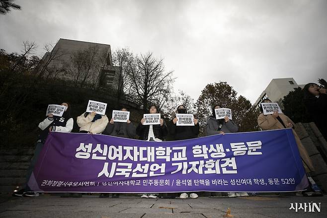 11월26일 오전 서울 성북구 성신여자대학교 정문 앞에서 열린 ‘성신여자대학교 학생·동문 시국선언 기자회견’에 참가한 재학생과 동문들이 손피켓을 들고 있다. ⓒ시사IN 이명익