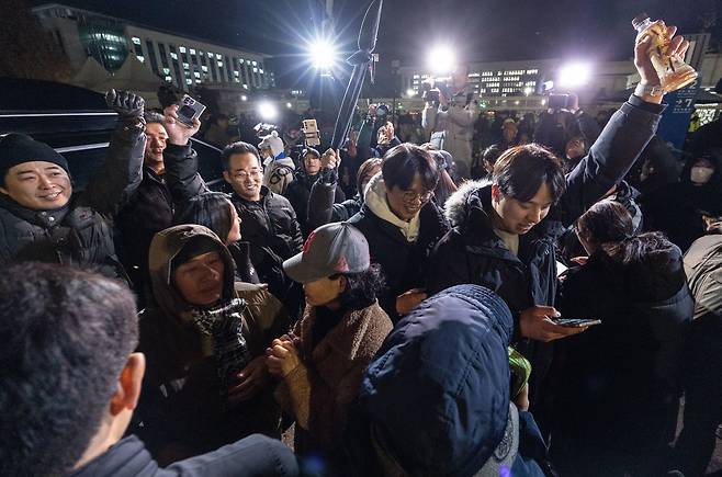 비상계엄 해제 요구 결의안이 국회 본회의에서 통과된 4일 새벽 국회 인근에서 시민들이 스마트폰으로 윤석열 대통령의 비상계엄 해제 담화 발표를 접하고 환호하고 있다. /뉴스1