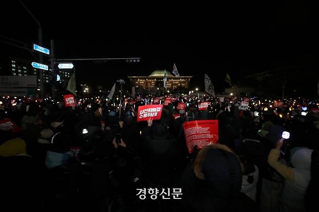 윤석열 대통령에 대한 탄핵소추안 표결이 진행된 7일 오후 서울 여의도 국회앞에서 열린 ‘범국민촛불대행진’ 참석자들이 탄핵안 부결에 항의하며 구호를 외치고 있다. 정효진 기자