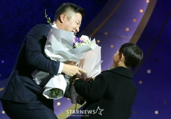 KIA 최형우(왼쪽)가 13일 오후 서울 강남구 삼성동 코엑스 오디토리움에서 진행된 '2024 신한은행 SOL 뱅크 KOB 골든글러브 시상식'에서 지명타자 부문 골든글러브를 수상한 뒤 아들에게 꽃다발을 받고 있다. /사진=김창현 기자