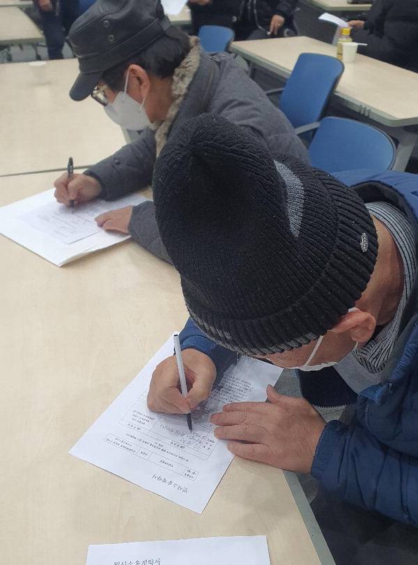 지난 20일 부산역 유라시아플랫폼에서 영화숙·재생원 피해생존자가 국가 상대 손해배상 청구 소송 위·수임 계약서를 작성하고 있다. 신심범 기자