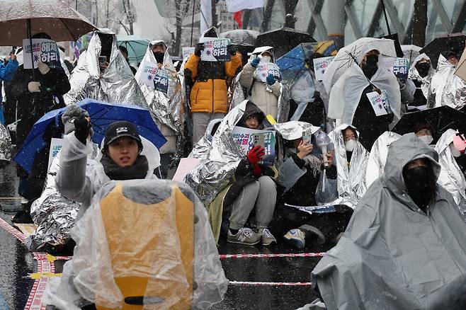 서울 전 지역에 대설주의보가 내려진 5일 오전 서울 용산구 관저 인근 ‘노동자 시민 윤석열 체포대회’ 농성장에서 은박지를 뒤집어쓴 시민들이 농성하고 있다. 김혜윤 기자 unique@hani.co.kr