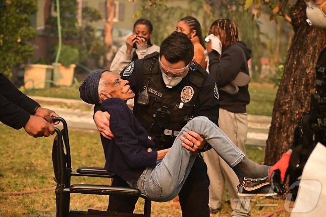 8일 (현지시간) 산불이 발생한 캘리포니아주 앨터디너에서 경찰이 주민을 대피시키고 있다. 2025.01.09 ⓒ AFP=뉴스1 ⓒ News1 우동명 기자