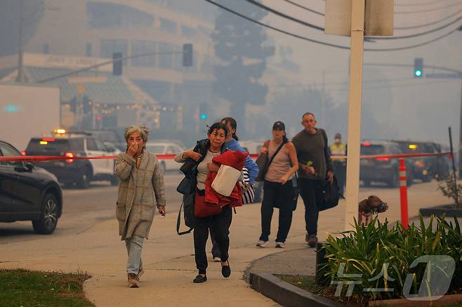 7일(현지시간) 미국 캘리포니아주 로스앤젤레스 서부의 퍼시픽 팰리세이즈 근처에서 주민들이 산불을 피해 스스로 대피하고 있다. 2025.01.07 ⓒ 로이터=뉴스1 ⓒ News1 김지완 기자