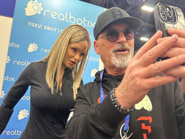 8일 미국 네바다주 라스베이거스 컨벤션센터에서 열린 소비자가전전시회(CES) 리얼보틱스 부스에서 휴머노이드 인공지능 로봇 '아리아'(왼쪽)가 "함께 사진을 찍자"는 한 참관객의 말에 스마트폰 쪽으로 고개를 들이밀고 있다. 라스베이거스=이서희 특파원