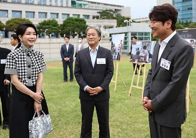 김건희 여사가 지난 2022년 6월 12일 서울 용산 대통령실 청사 잔디마당에서 열린 영화관계자 초청 만찬에서 그해 칸국제영화제 남우주연상을 받은 배우 송강호, 감독상을 수상한 박찬욱 감독과 대화하고 있다. 연합뉴스