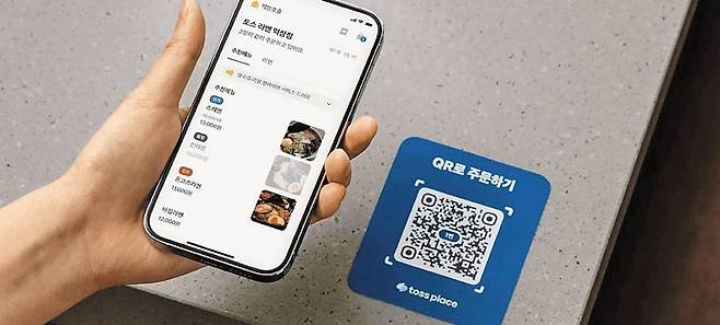 QR 코드가 식당에서 확산되고 있다. 스마트폰 카메라 화면만 비춰도 QR 코드를 인식해 주문이 가능한 데다, 키오스크나 태블릿 PC 같은 별도 기기가 필요 없고 자리도 덜 차지해서다. 사진은 스마트폰으로 QR 코드를 찍어 음식을 주문하는 모습. /토스플레이스