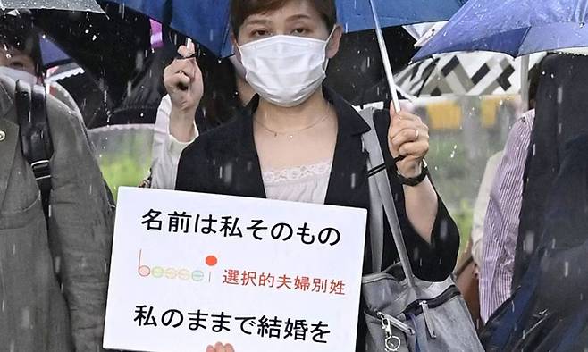 일본 한 여성이 선택적 부부별성제를 주장하며 “이름을 나 그 자체, 나인 채로 결혼을”이라고 쓰인 팻말을 들고 있다. 교도통신