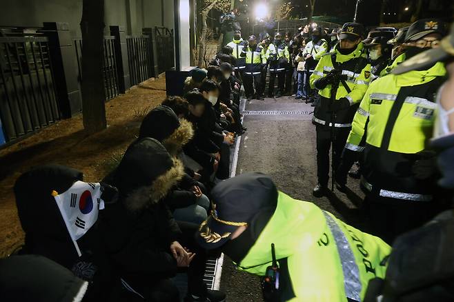 내란 우두머리 혐의로 체포된 윤석열 대통령이 출석한 가운데 구속 전 피의자심문(영장실질심사)이 열린 1월18일 서울 마포구 서울서부지법에서 윤 대통령 지지자들이 법원 담장을 넘어와 경찰들에게 연행돼 있다. ⓒ 연합뉴스