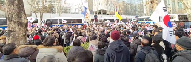 18일 오후 서울 마포구 서울서부지법 인근에서 한 남성이 승합차 위로 올라가서 윤석열 대통령 지지 구호를 선창하고 있다. 유튜브 채널 '젊은시각' 캡처