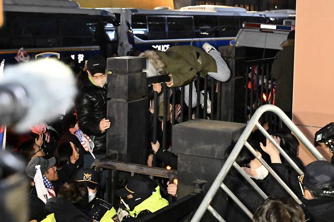 내란 우두머리 혐의를 받는 윤석열 대통령이 구속된 가운데 19일 서울 마포구 서울서부지법에서 윤 대통령 지지자들이 법원 담장을 넘으려 시도하고 있다. 연합뉴스