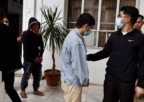 필리핀 당국에 검거된 중국인 간첩 덩 위안칭(오른쪽에서 2번째)이 20일(현지시간) 필리핀 수도 마닐라에서 경찰에 의해 호송되는 모습. EPA=연합뉴스